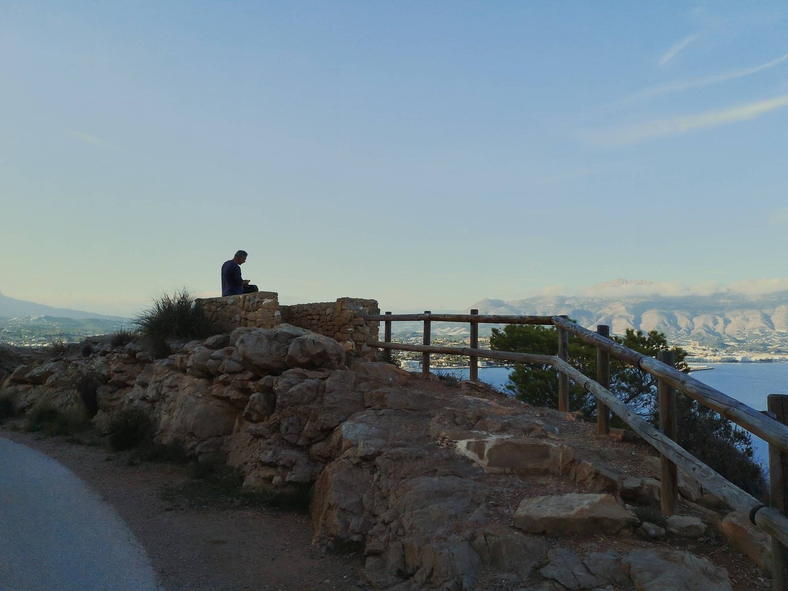 Man sitting on a rock on Camino del Faro in Serra Gelada, Spain